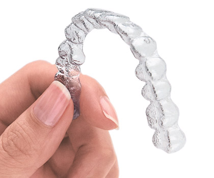 Picture of a hand holding the clear Invisalign tray