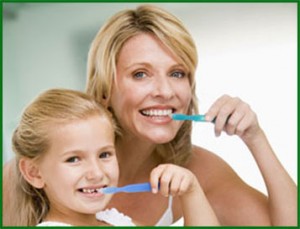 Picture of a mother a daughter brushing and practicing good dental care to prevent periodontal disease.
