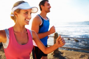 Picture of a smiling couple running on the beach.