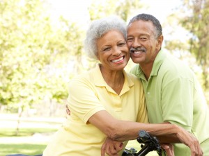 Smiling couple showing off their implanted dentures