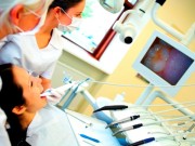 Picture of a patient in a chair using an intraoral camera to detect decay.